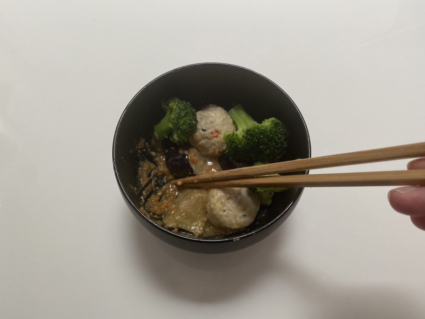 お椀の中で味噌を溶いている画像