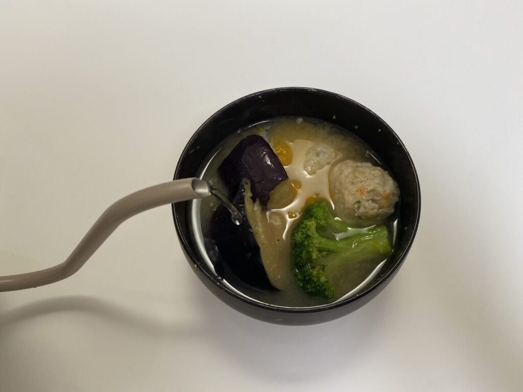 味噌を溶いたお椀にお湯を注いでいる画像